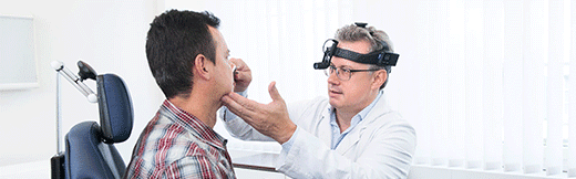 Dr. med. Domeisen untersucht die Nase eines Patienten mit einem modernen Gerät